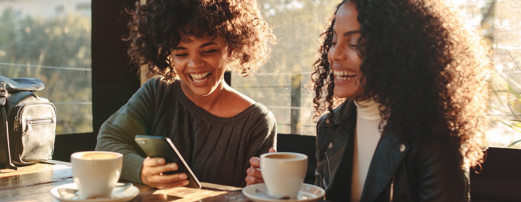 two women smiling at a phone